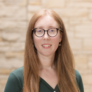 Photo of a white woman wearing glasses with long strawberry blond hair.