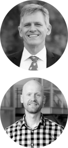 headshots for two white men; top man has short gray hair and wears a suit; bottom man has buzzed hair and a beard