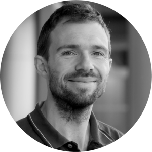 headshot of a white man with short brown hair and a beard