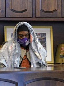 Michael Singletary rests behind a desk at a Gallery Furniture store which opened as a shelter for those without power Wednesday, Feb. 17, 2021, in Houston. Millions in Texas still had no power after a historic snowfall and single-digit temperatures created a surge of demand for electricity to warm up homes unaccustomed to such extreme lows, buckling the state’s power grid and causing widespread blackouts. David J. Phillip/AP Photo
