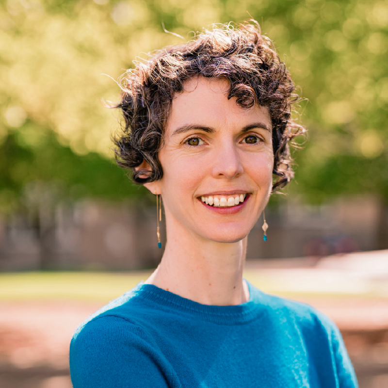 Headshot of a white woman with short, curly gray hair