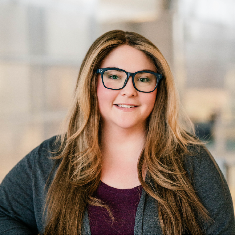 headshot of a white women with long brown hair and glasses