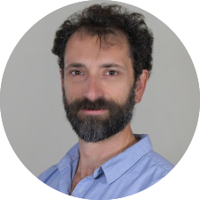 headshot of a white man with short brown hair and beard