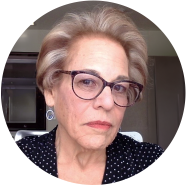 headshot of a light skinned woman with short blond hair and glasses