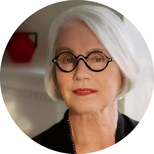 headshot of a white woman with a short white bob and glasses