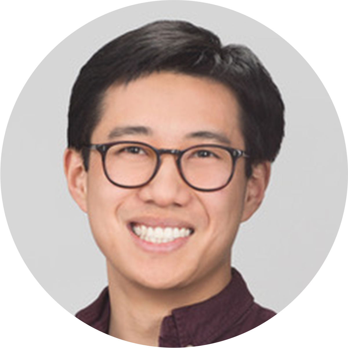 headshot of an asian man with short black hair and glasses